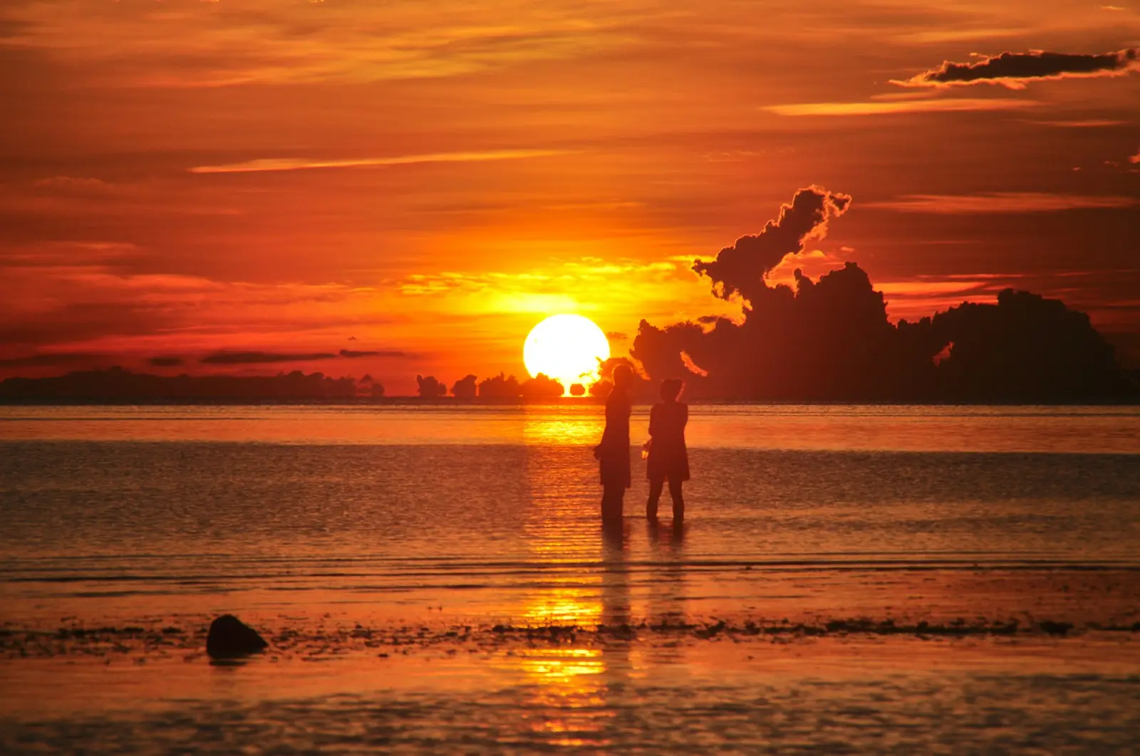 Silhouettes on a Thai beach at sunset